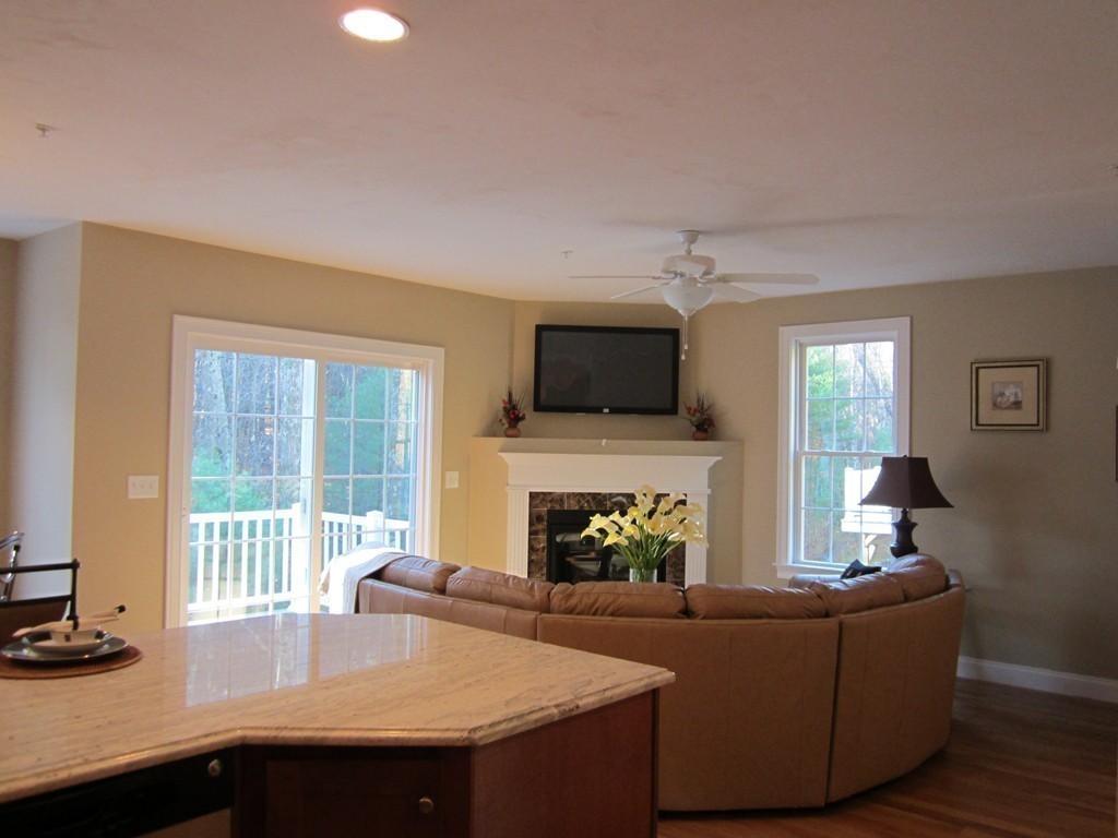 117 Dudley Road, Unit 117 Berlin, MA 01503 - Photo 8 of 21 a living room with furniture a flat screen tv and a fireplace
