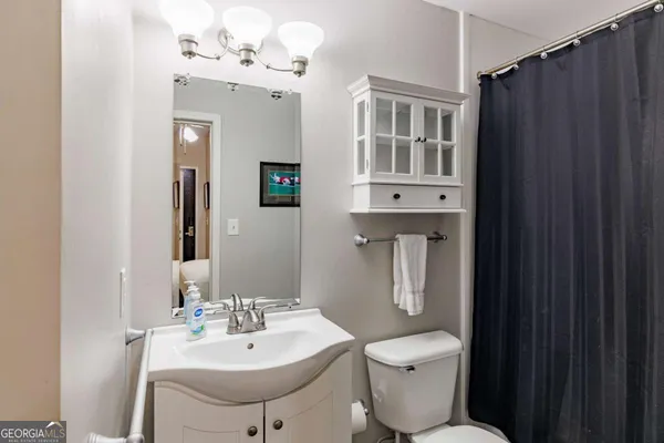 a bathroom with a toilet sink and mirror