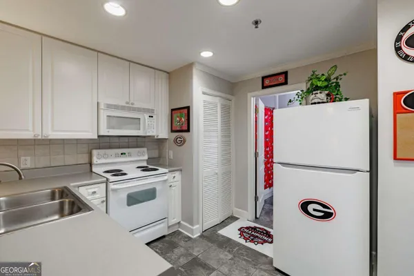 a kitchen with stainless steel appliances a refrigerator sink and white cabinets