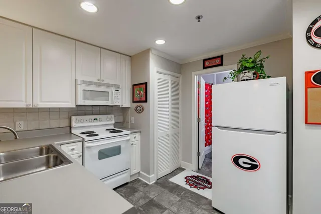 a kitchen with stainless steel appliances a refrigerator sink and white cabinets
