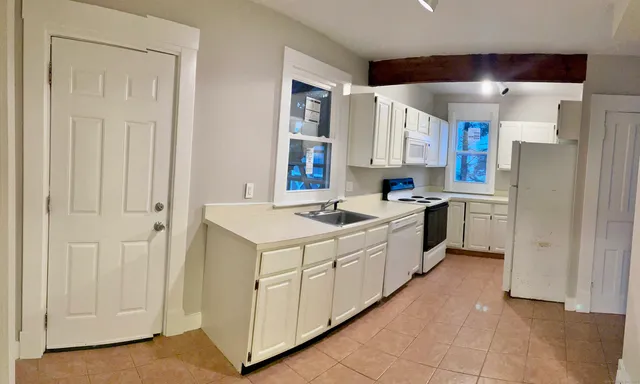 a kitchen with white cabinets and white appliances