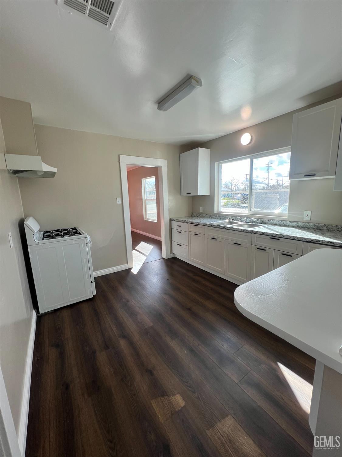 Undisclosed Address Bakersfield, CA 93304 - Photo 4 of 11 a large kitchen with cabinets wooden floor and a sink