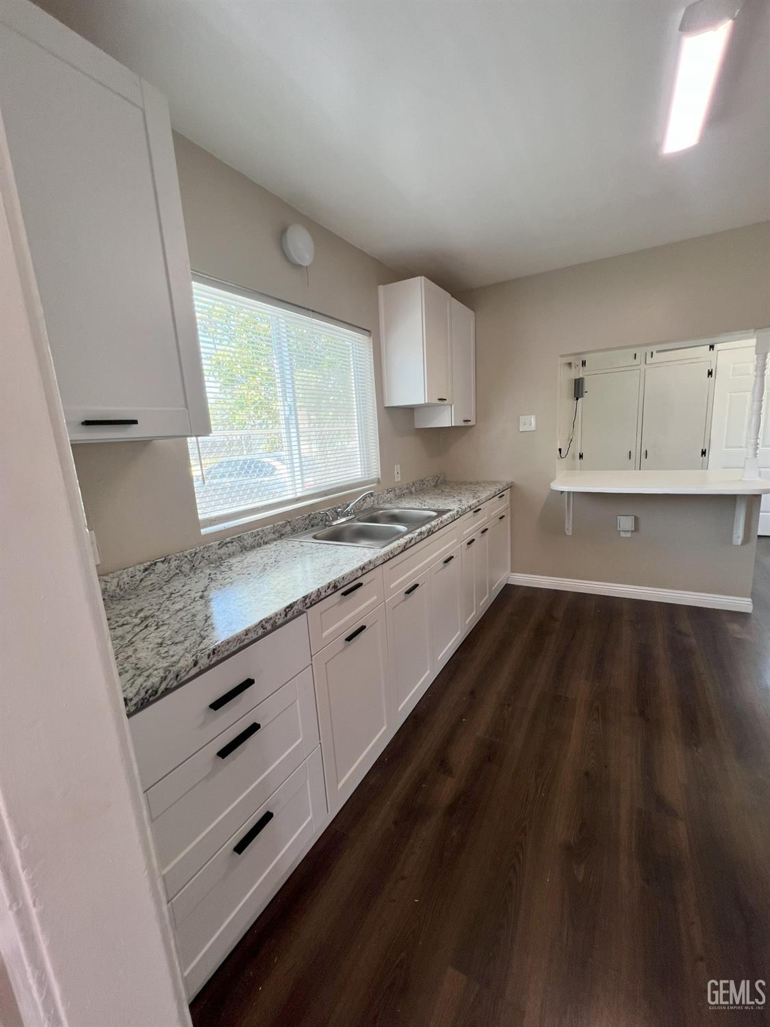Undisclosed Address Bakersfield, CA 93304 - Photo 6 of 11 a kitchen with granite countertop a stove a sink and a refrigerator