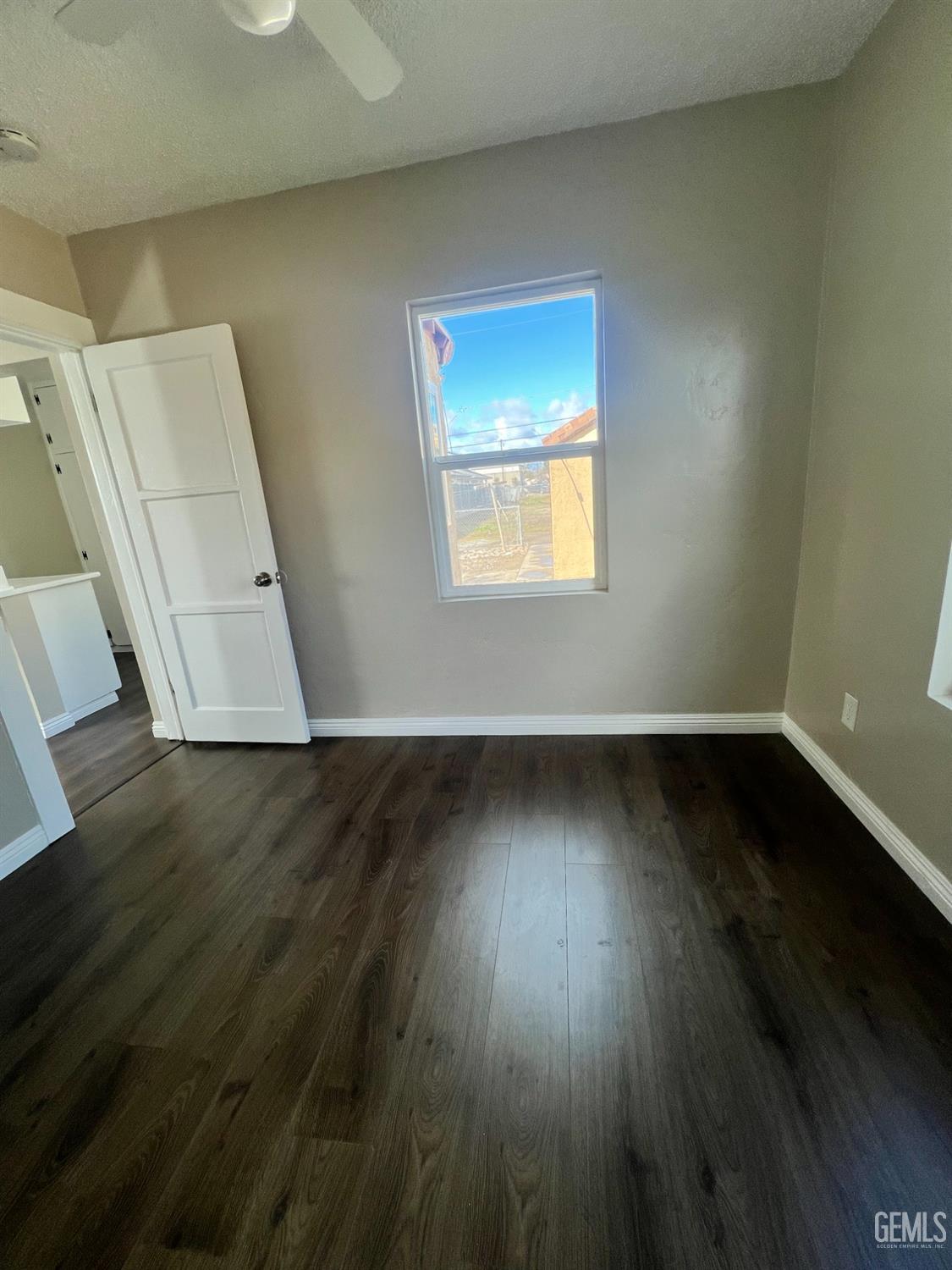 Undisclosed Address Bakersfield, CA 93304 - Photo 9 of 11 a view of an empty room with wooden floor and a window