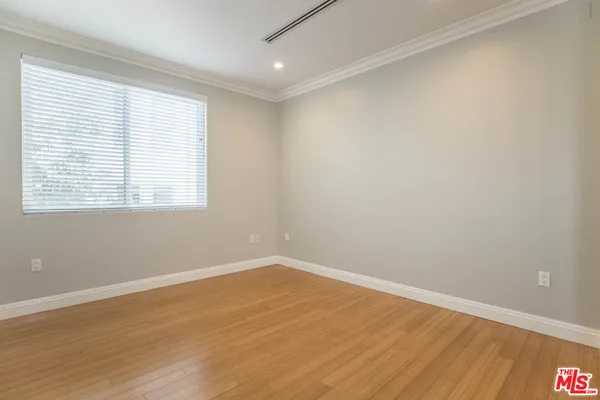 an empty room with wooden floor and a window
