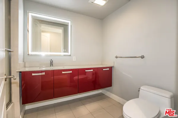 a bathroom with a toilet a sink and mirror