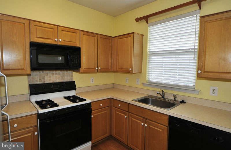 11408 Gate Hill Place, Unit O Reston, VA 20194 - Photo 7 of 30 a kitchen with a sink a stove and cabinets