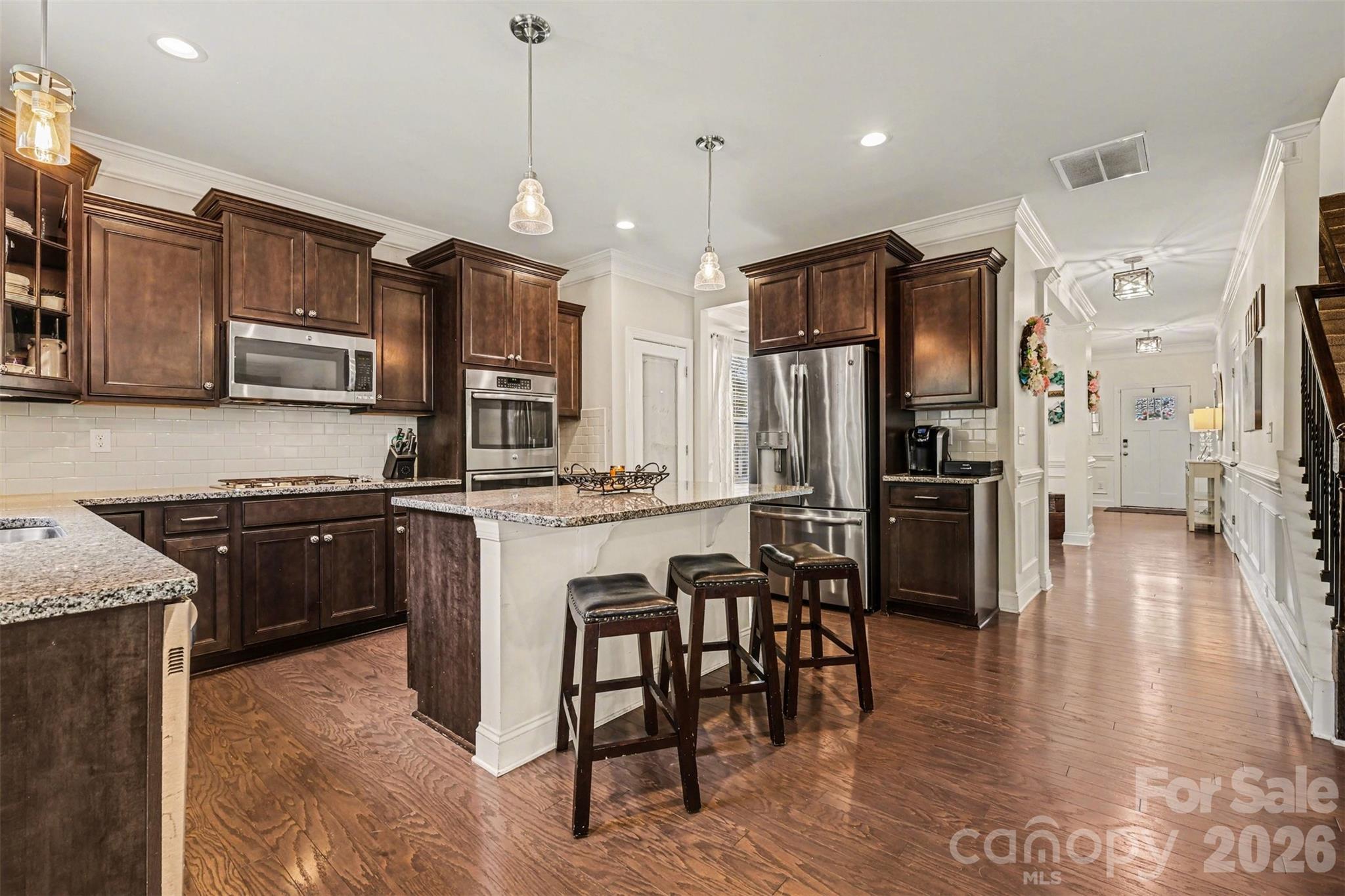850 Coralbell Way Fort Mill, SC 29708 - Photo 9 of 48 a kitchen with stainless steel appliances granite countertop a refrigerator a stove a sink a dining table and chairs with wooden floor
