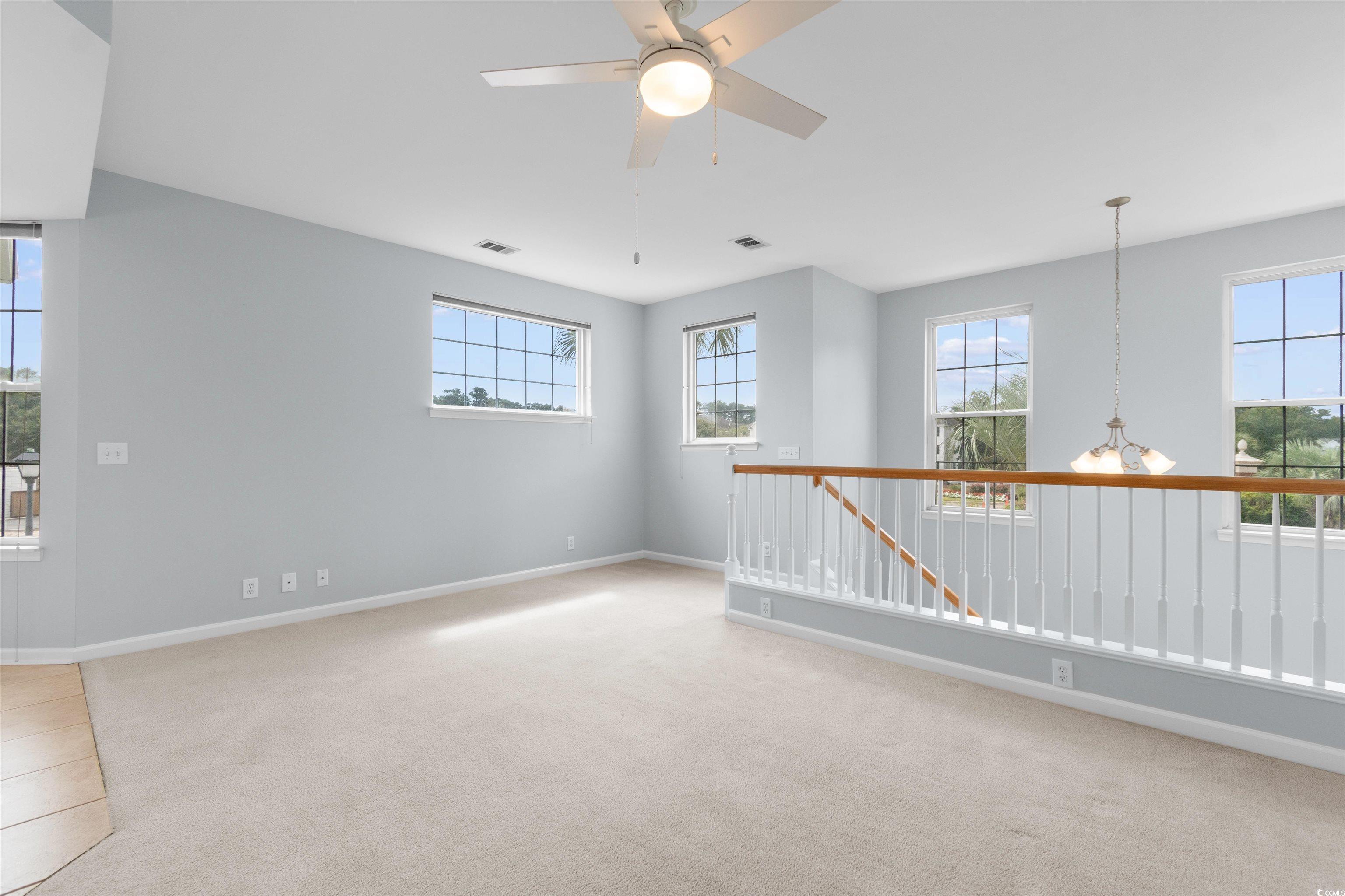 4430 Lady Banks Lane, Unit A2 Murrells Inlet, SC 29576 - Photo 16 of 31 Spare room featuring light colored carpet, plenty of natural light, a chandelier, and a ceiling fan