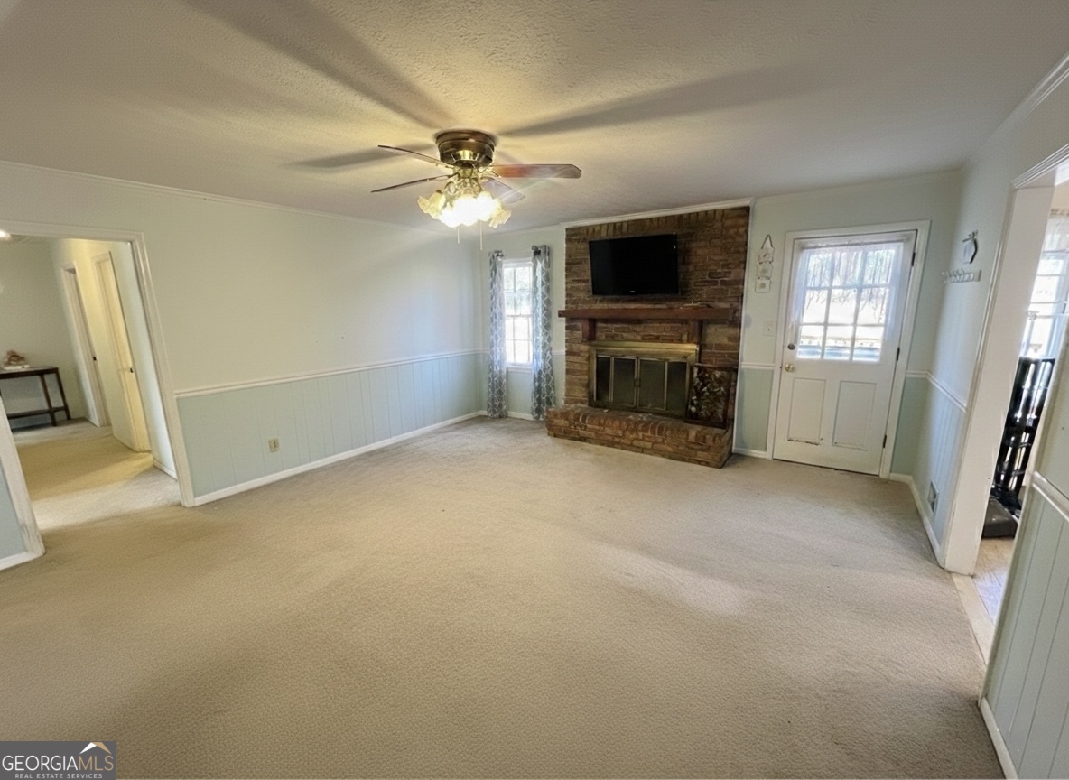 211 Clark Road Griffin, GA 30224 - Photo 3 of 25 an empty room with windows fireplace and a ceiling fan