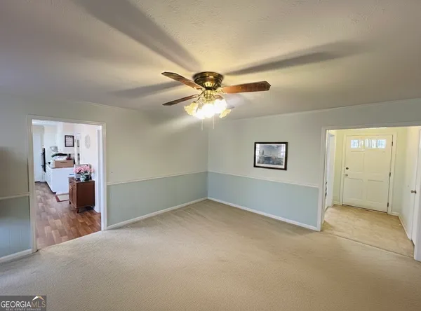 an empty room and chandelier fan