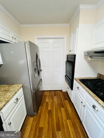 a kitchen with white cabinets and appliances