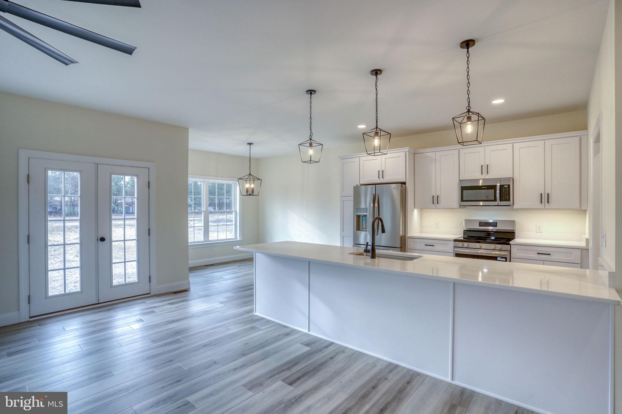 3150 Old Sharptown Road Laurel, DE 19956 - Photo 20 of 46 a kitchen with stainless steel appliances granite countertop wooden floors sink and cabinets