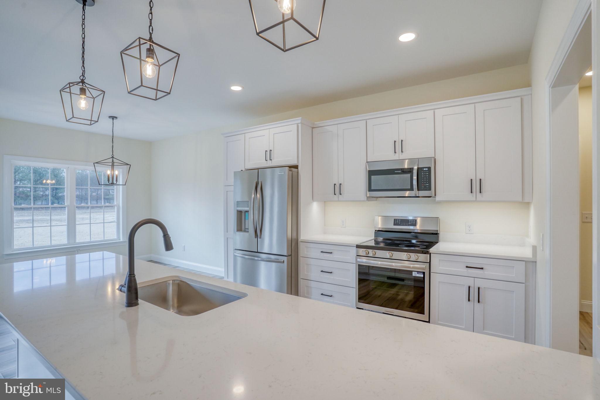 3150 Old Sharptown Road Laurel, DE 19956 - Photo 21 of 46 a kitchen with stainless steel appliances granite countertop a sink a stove and a refrigerator with wooden floor