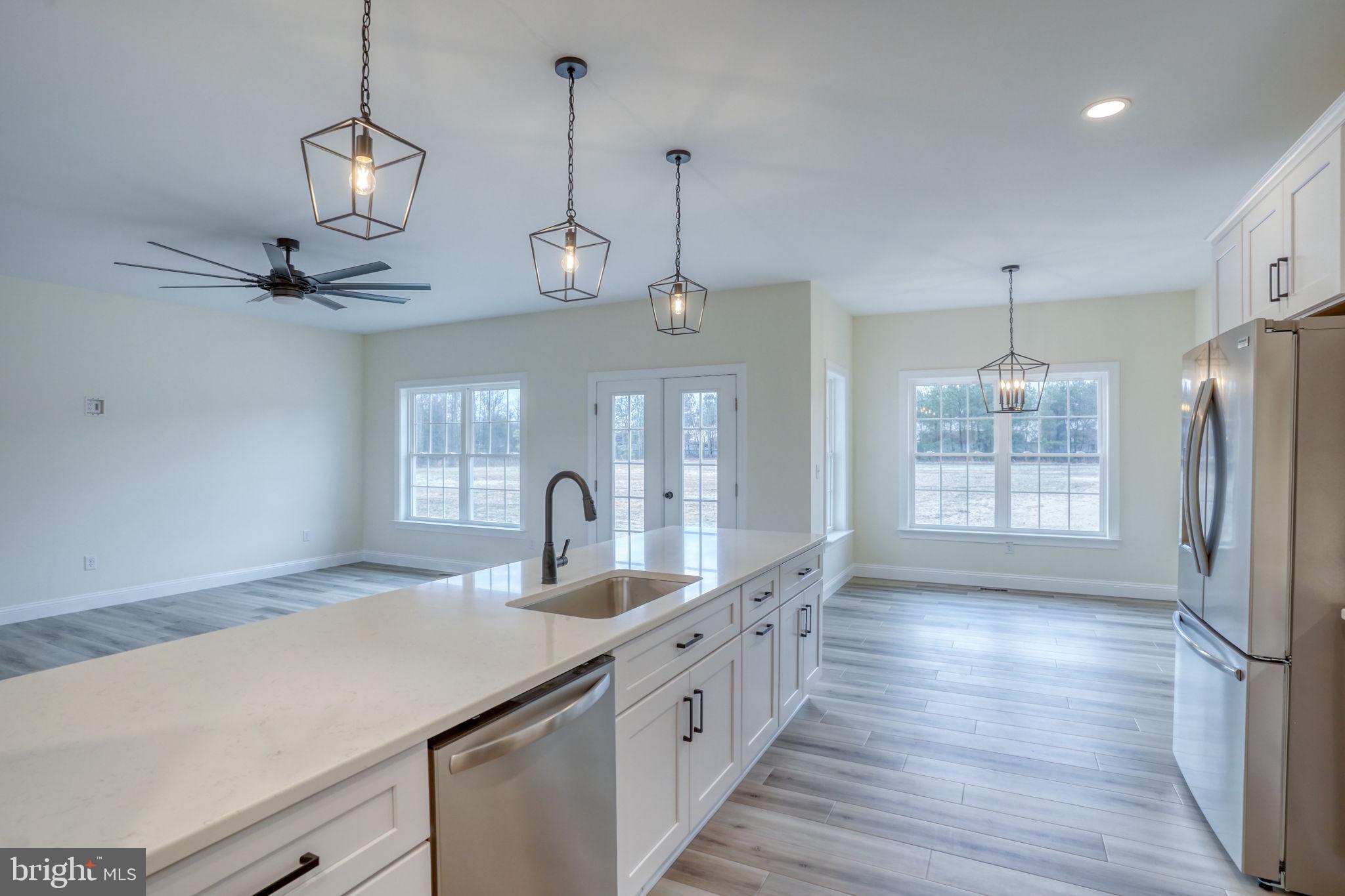 3150 Old Sharptown Road Laurel, DE 19956 - Photo 22 of 46 a kitchen with stainless steel appliances granite countertop a sink a refrigerator a center island a stove and a window