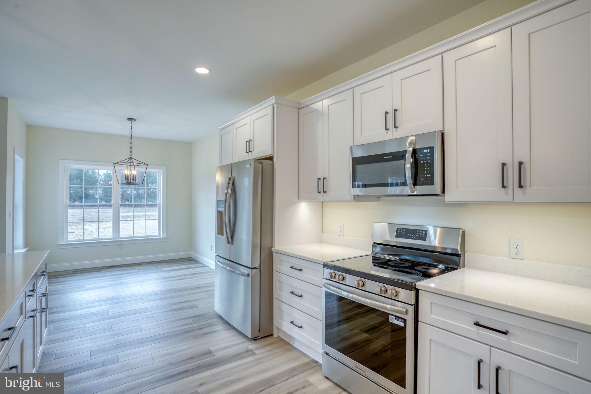 3150 Old Sharptown Road Laurel, DE 19956 - Photo 23 of 46 a kitchen with stainless steel appliances a stove a microwave and a hard wood floors