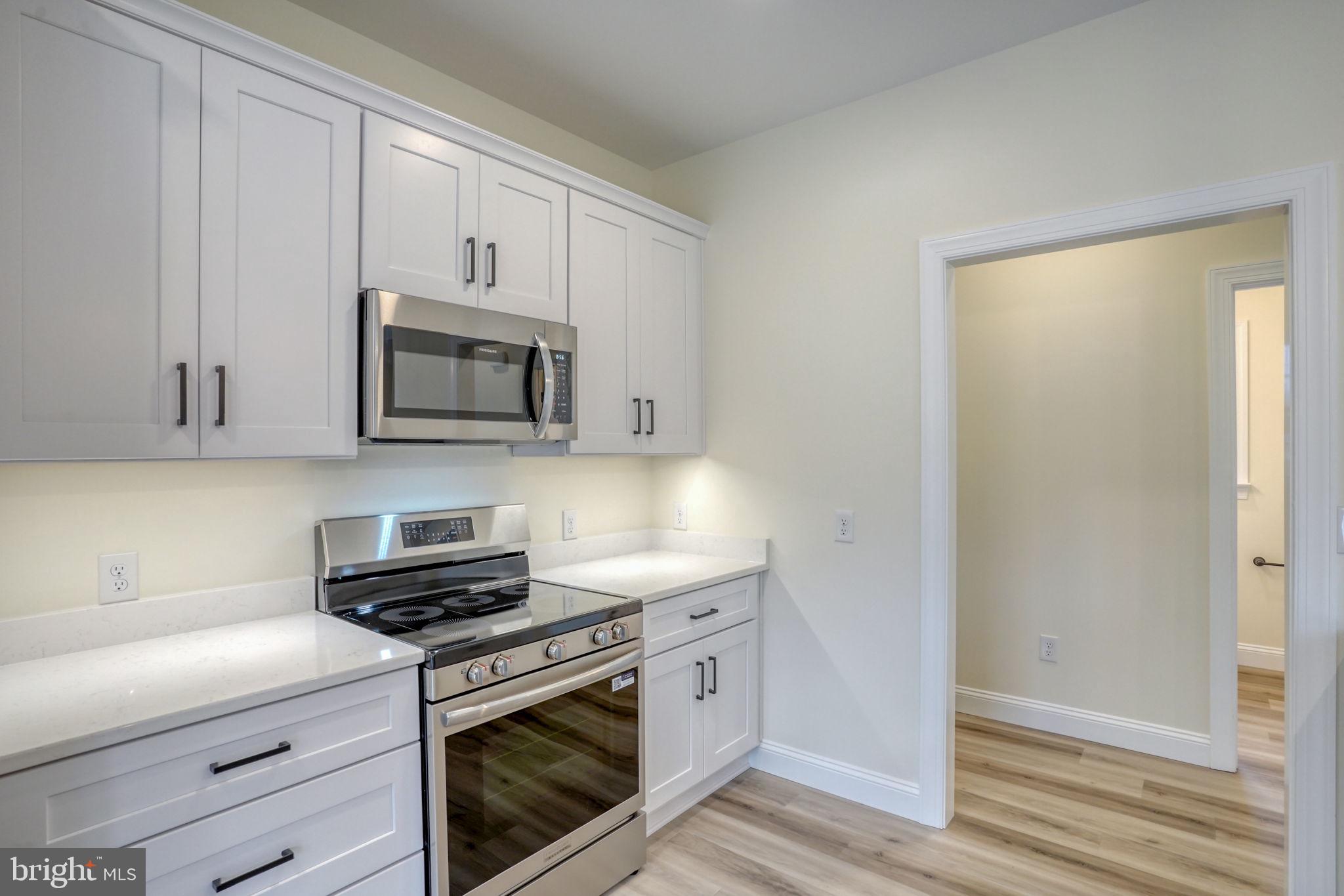 3150 Old Sharptown Road Laurel, DE 19956 - Photo 24 of 46 a kitchen with white cabinets and stainless steel appliances