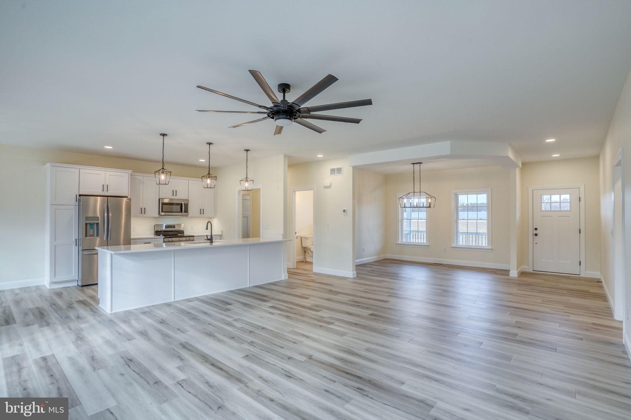 3150 Old Sharptown Road Laurel, DE 19956 - Photo 29 of 46 a view of an empty room and kitchen with wooden floor
