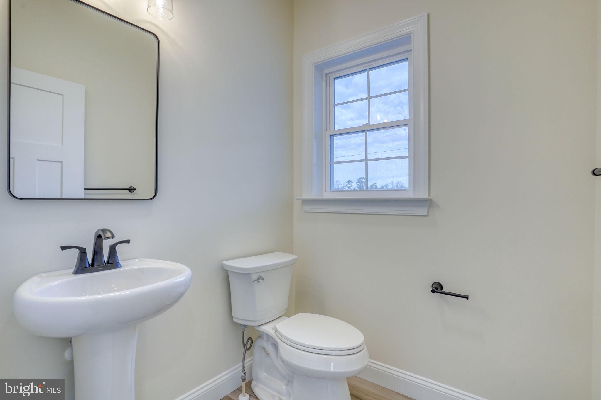 3150 Old Sharptown Road Laurel, DE 19956 - Photo 30 of 46 a bathroom with a toilet sink and mirror