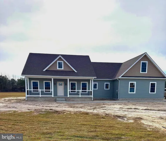 a front view of a house with a garden and lake view