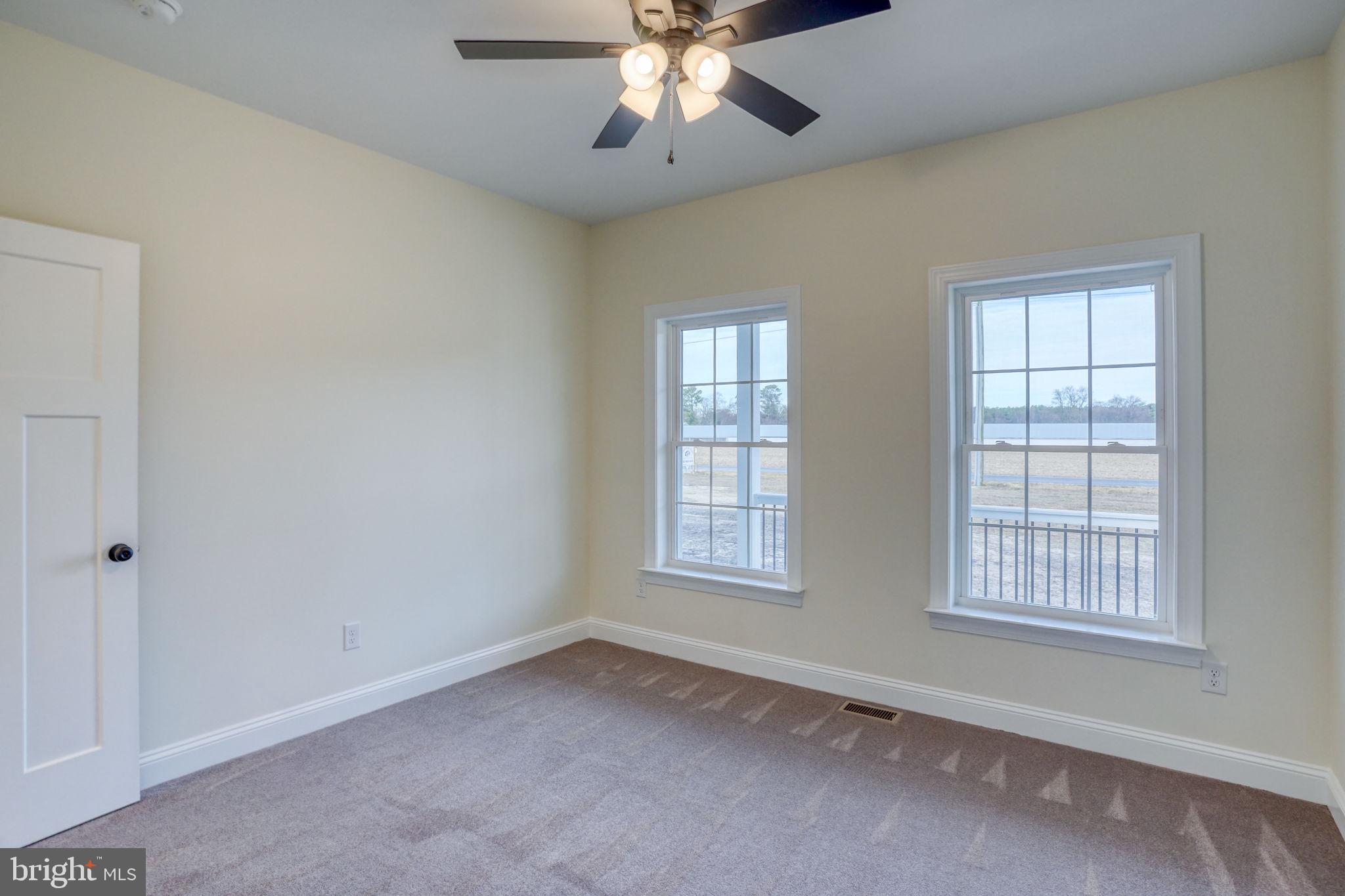 3150 Old Sharptown Road Laurel, DE 19956 - Photo 39 of 46 an empty room with chandelier fan and windows