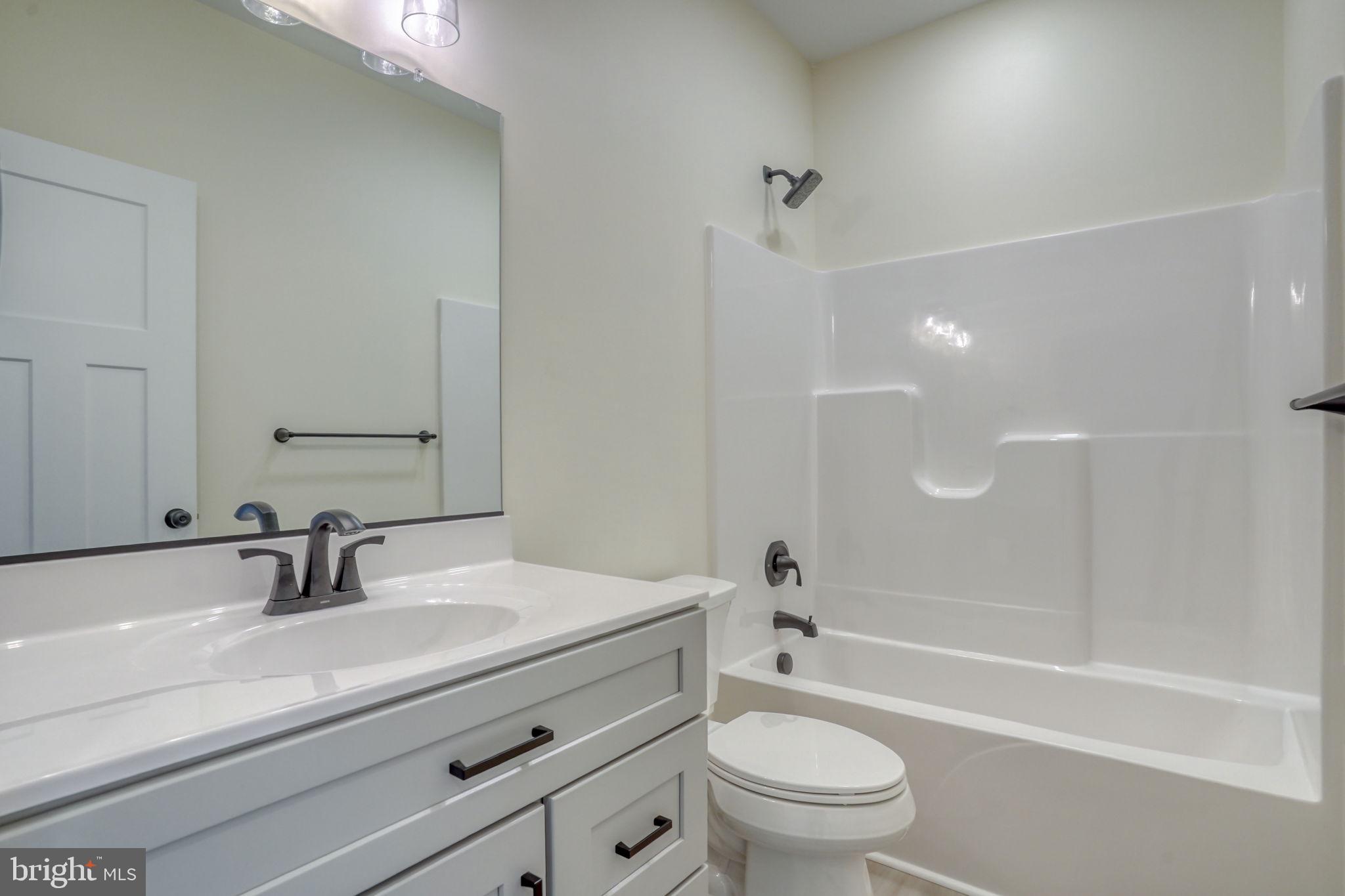 3150 Old Sharptown Road Laurel, DE 19956 - Photo 40 of 46 a bathroom with a sink a toilet and a large mirror