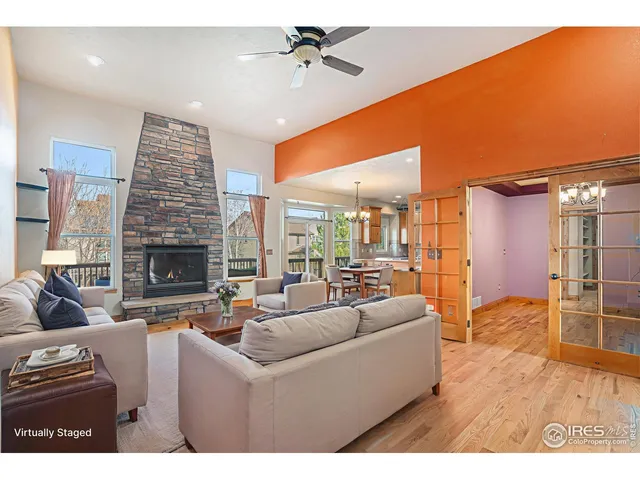 a view of an empty room with wooden floor a fireplace and window