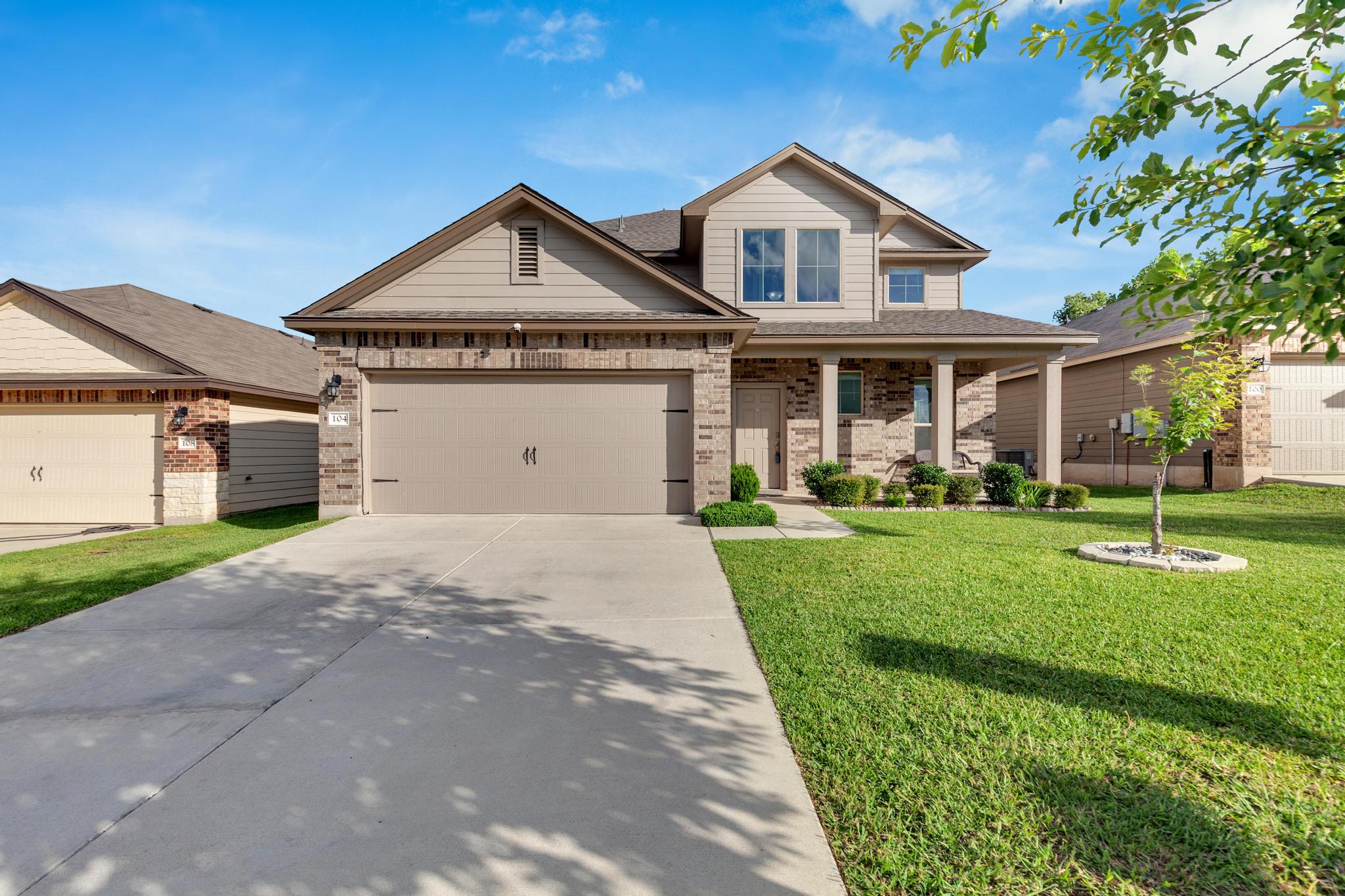 A welcoming facade with a covered entry and attached garage defines this suburban residence.