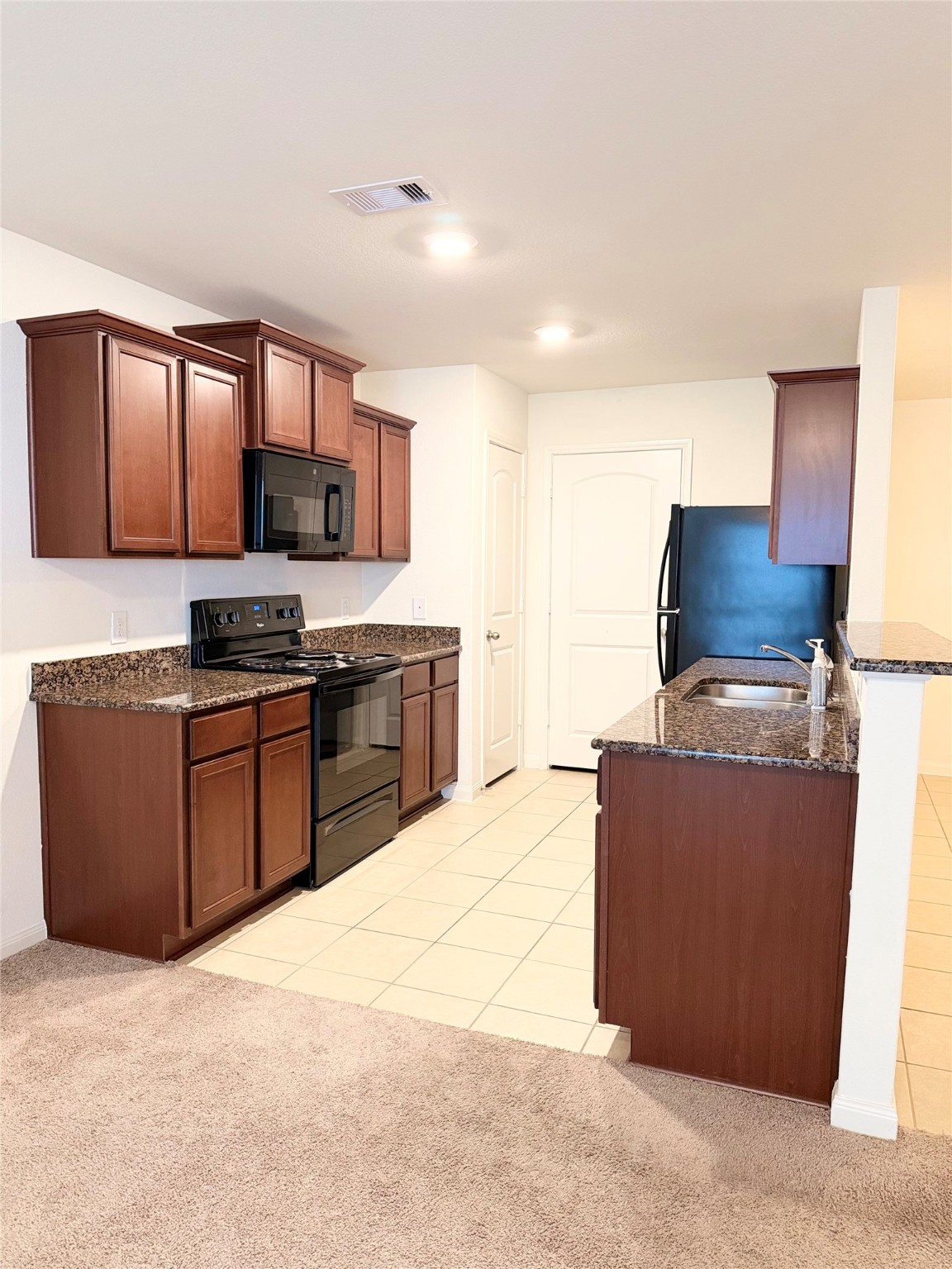 22418 Threefold Ridge Drive Hockley, TX 77447 - Photo 6 of 19 a kitchen with stainless steel appliances granite countertop a stove a sink and a refrigerator