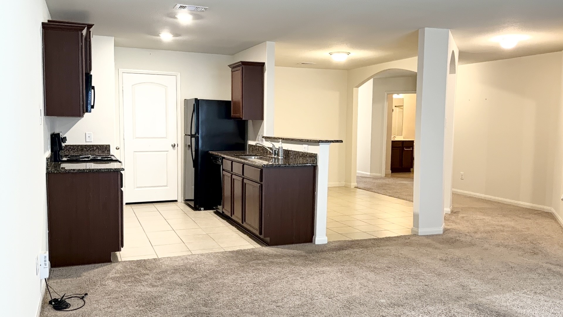 22418 Threefold Ridge Drive Hockley, TX 77447 - Photo 7 of 19 a kitchen with stainless steel appliances kitchen island granite countertop a refrigerator and a stove