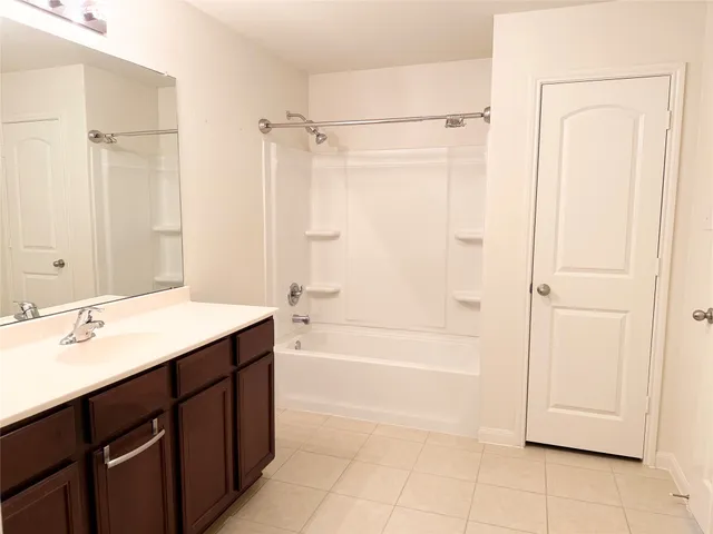 a bathroom with a tub sink and mirror