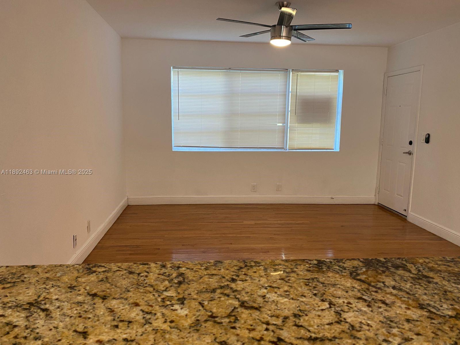 340 84th Street, Unit 2 Miami Beach, FL 33141 - Photo 4 of 10 an empty room with wooden floor fan and windows