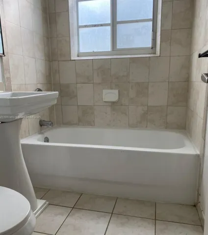 a white bath tub sitting next to a white toilet