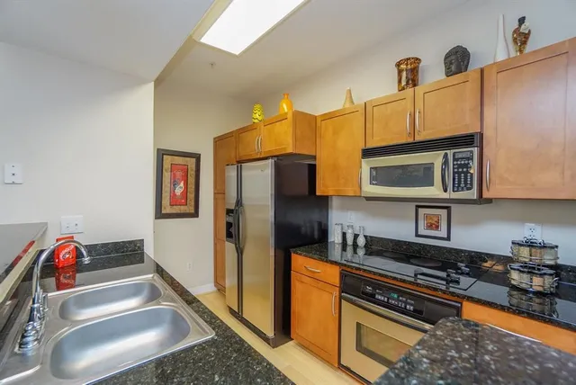 a kitchen with stainless steel appliances granite countertop a refrigerator and a stove top oven