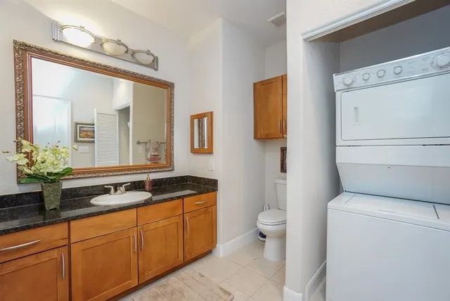 a spacious bathroom with a granite countertop sink a toilet and a mirror