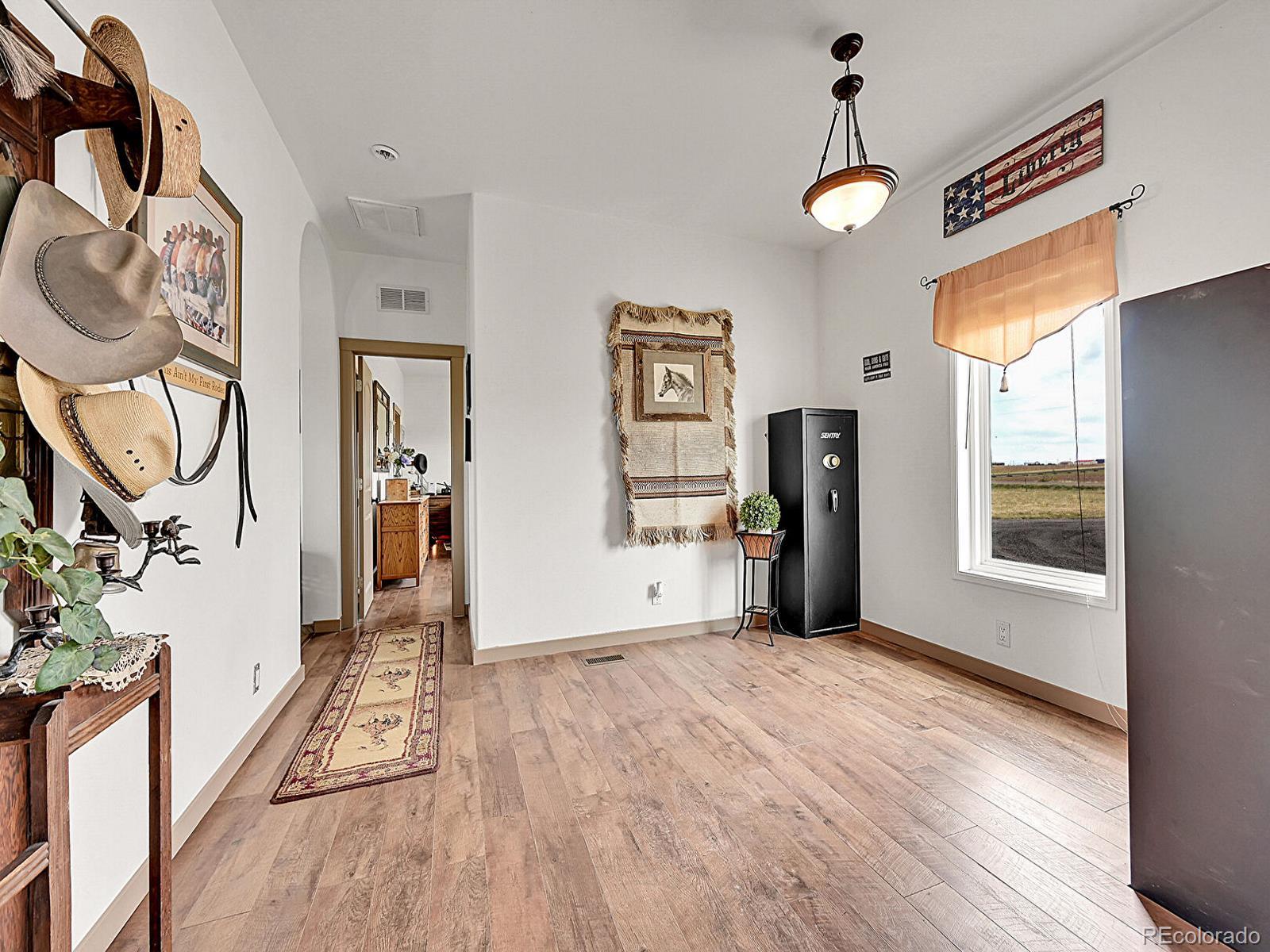 10660 Schumaker Road Bennett, CO 80102 - Photo 11 of 50 a view of a room with wooden floor and windows
