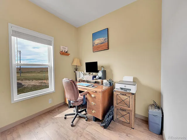 a view of a workspace with furniture and a window