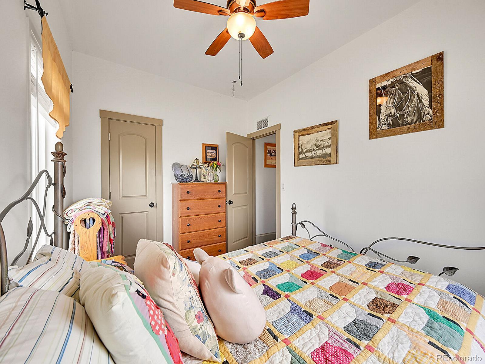 10660 Schumaker Road Bennett, CO 80102 - Photo 16 of 50 a bedroom that has a bed and a chandelier