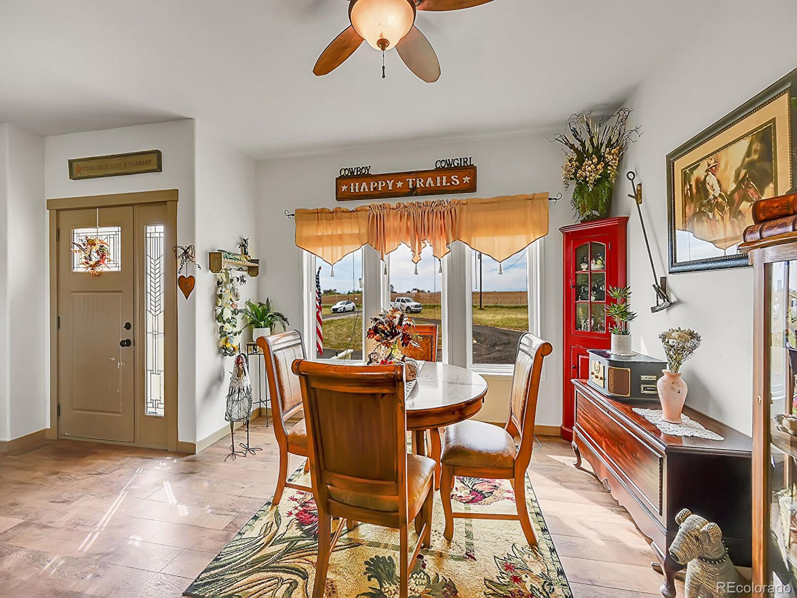 10660 Schumaker Road Bennett, CO 80102 - Photo 18 of 50 a dining room with furniture a flat screen tv and a large window