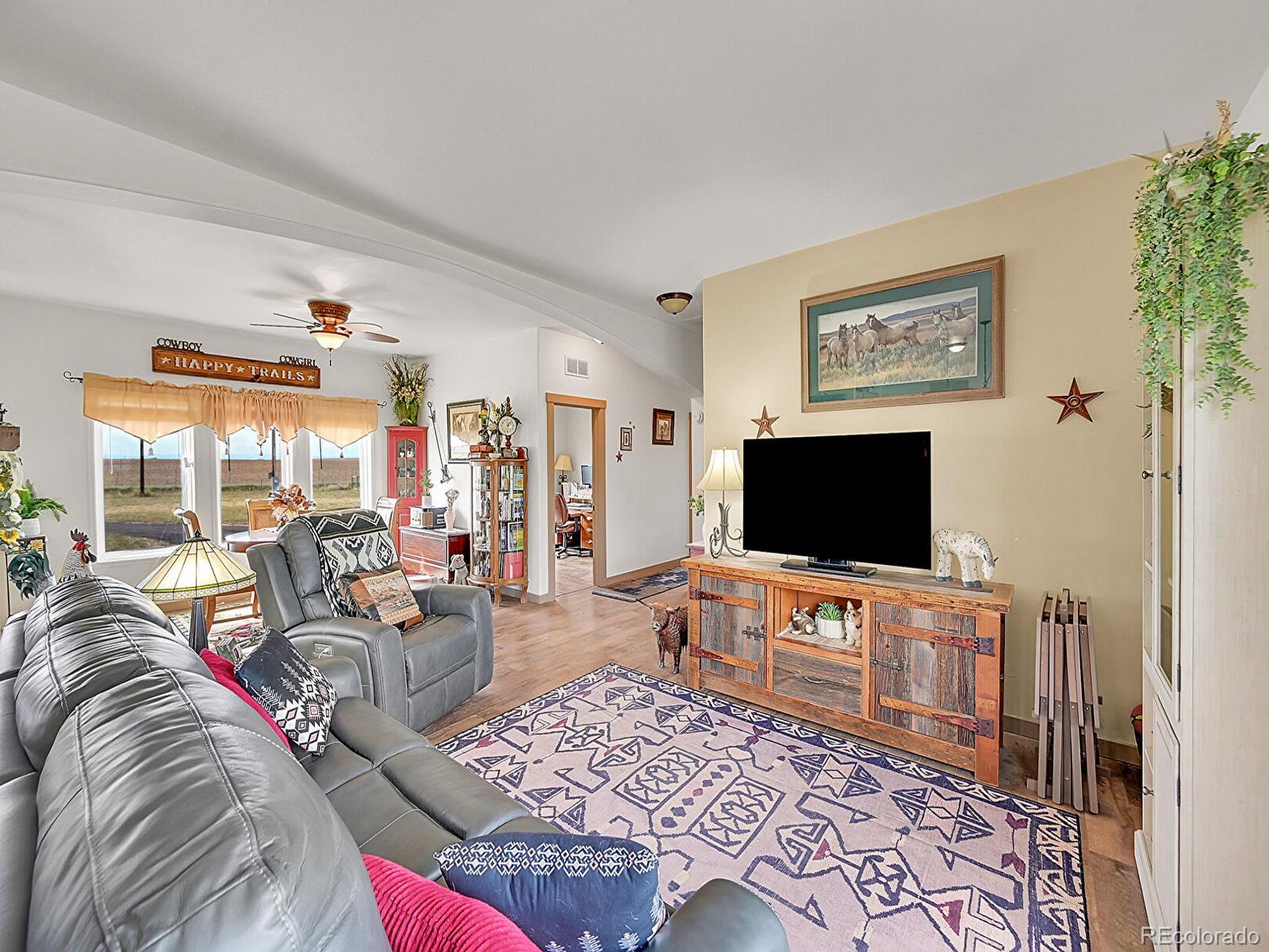 10660 Schumaker Road Bennett, CO 80102 - Photo 19 of 50 a living room with furniture and a flat screen tv