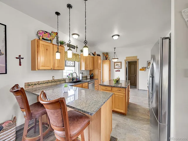 a kitchen with stainless steel appliances granite countertop a kitchen island a stove and a refrigerator