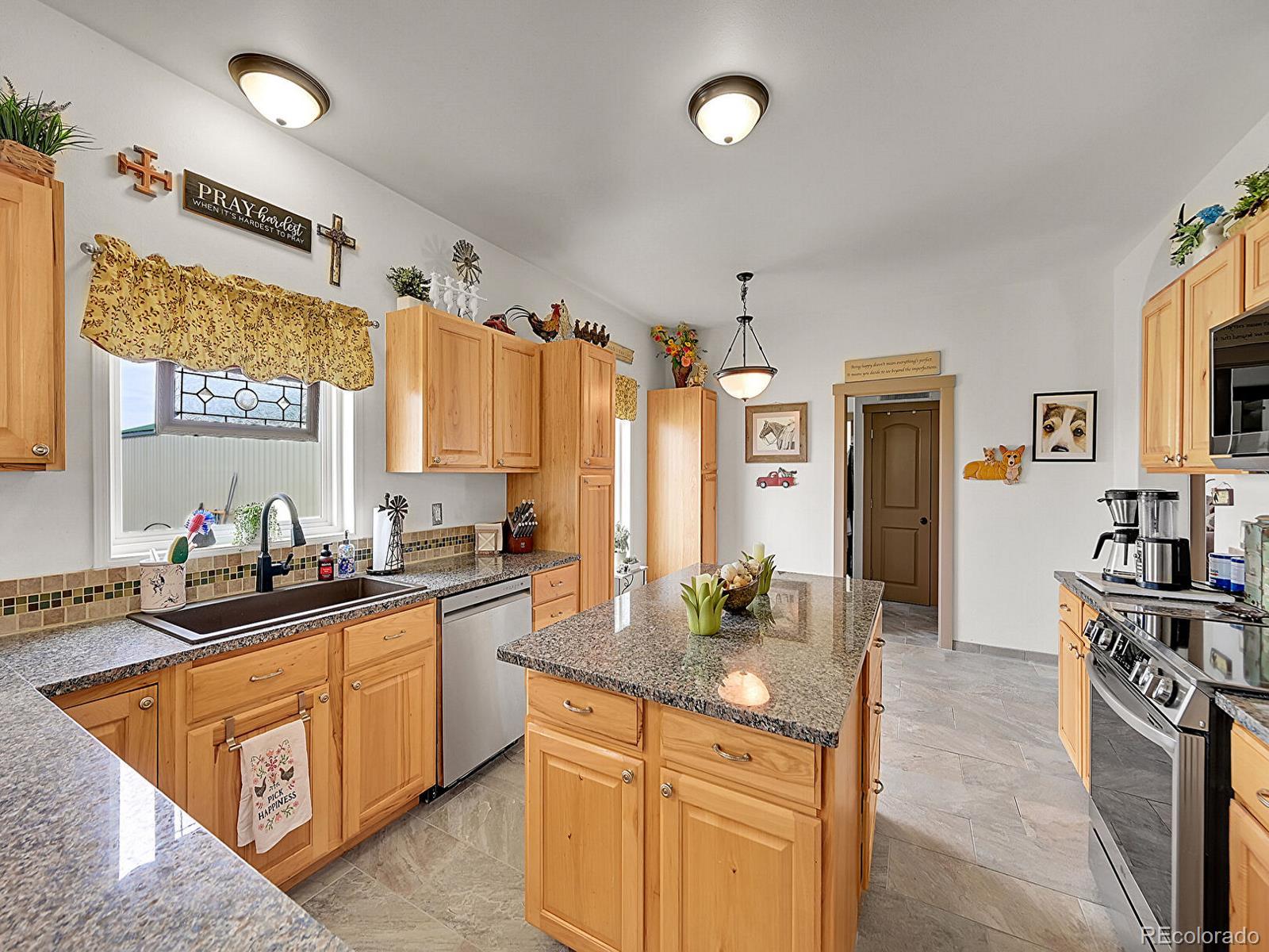 10660 Schumaker Road Bennett, CO 80102 - Photo 24 of 50 a kitchen with stainless steel appliances a sink stove and refrigerator