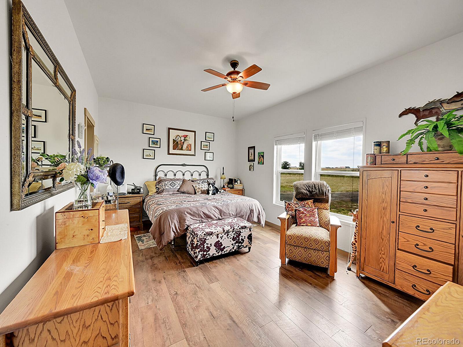 10660 Schumaker Road Bennett, CO 80102 - Photo 4 of 50 a bedroom with a bed and wooden floor
