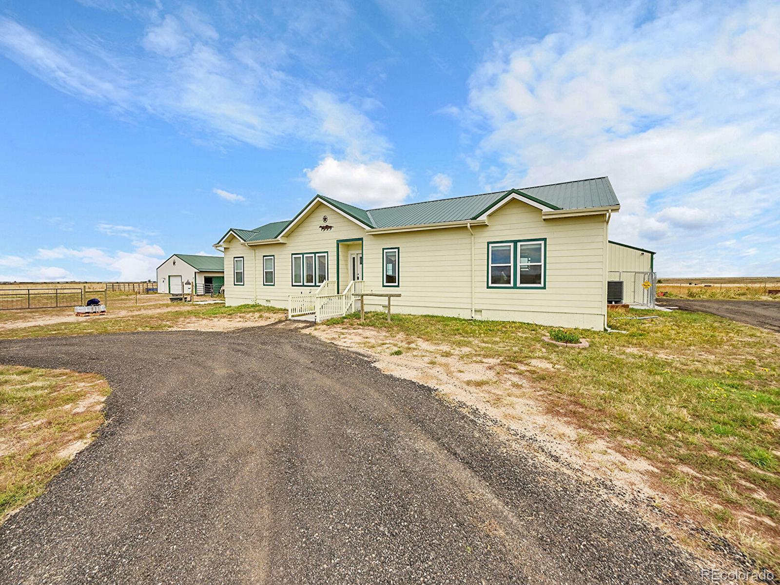 10660 Schumaker Road Bennett, CO 80102 - Photo 6 of 50 a view of a house with a big yard and large trees