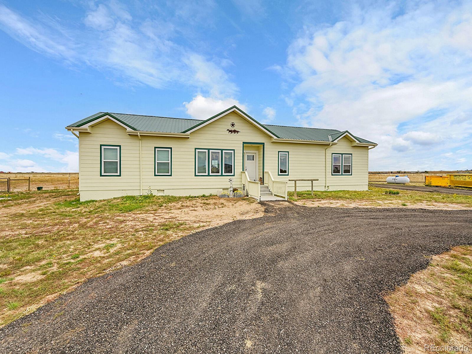 10660 Schumaker Road Bennett, CO 80102 - Photo 7 of 50 a front view of a house with a yard and lake view