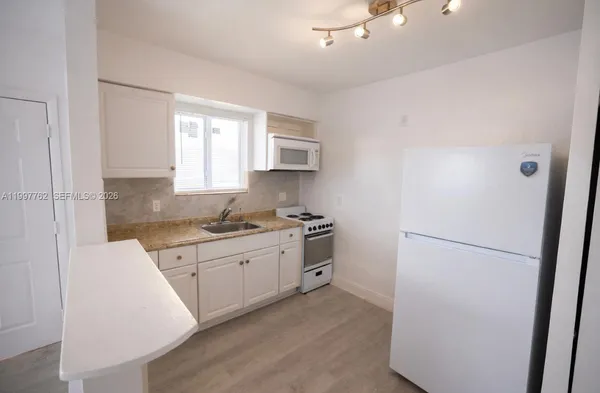 a kitchen with a sink a refrigerator and window