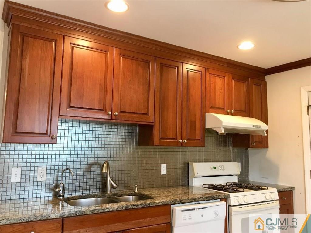23 Raleigh Road Edison, NJ 08817 - Photo 3 of 19 a kitchen with stainless steel appliances wooden cabinets and a stove top oven
