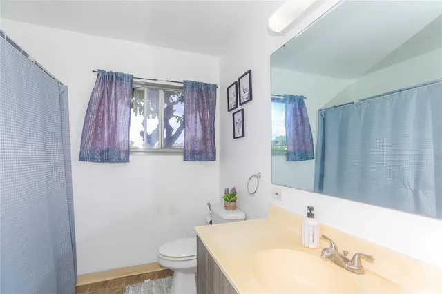 a bathroom with a sink a toilet and a mirror