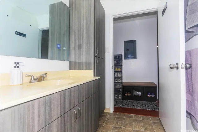 a bathroom with a granite countertop sink a mirror and shower