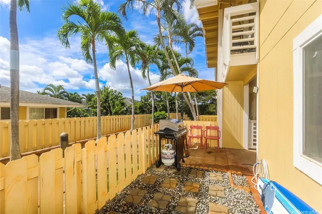 a view of a patio with table and chairs under an umbrella with wooden floor